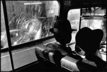 On a public bus in Jerusalem, two Orthodox Jewish Israelis ignore a window damaged by stone throwing Palestinians.