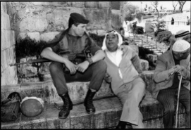 At an entrance to the old city of Jerusalem, a Palestinian and an Israeli sit together and talk.